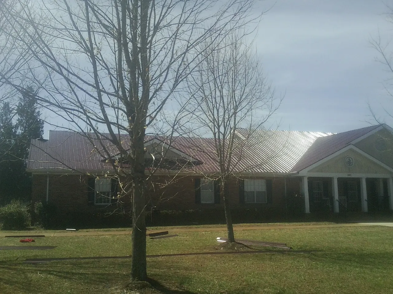 Red metal roof on a brick building seen from the front lawn in Saint Joseph